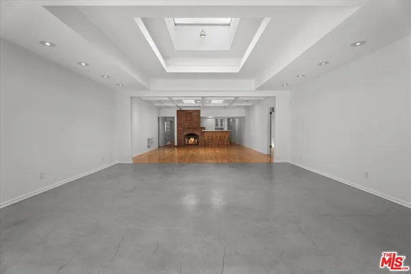 a view of a big room with chandelier and windows
