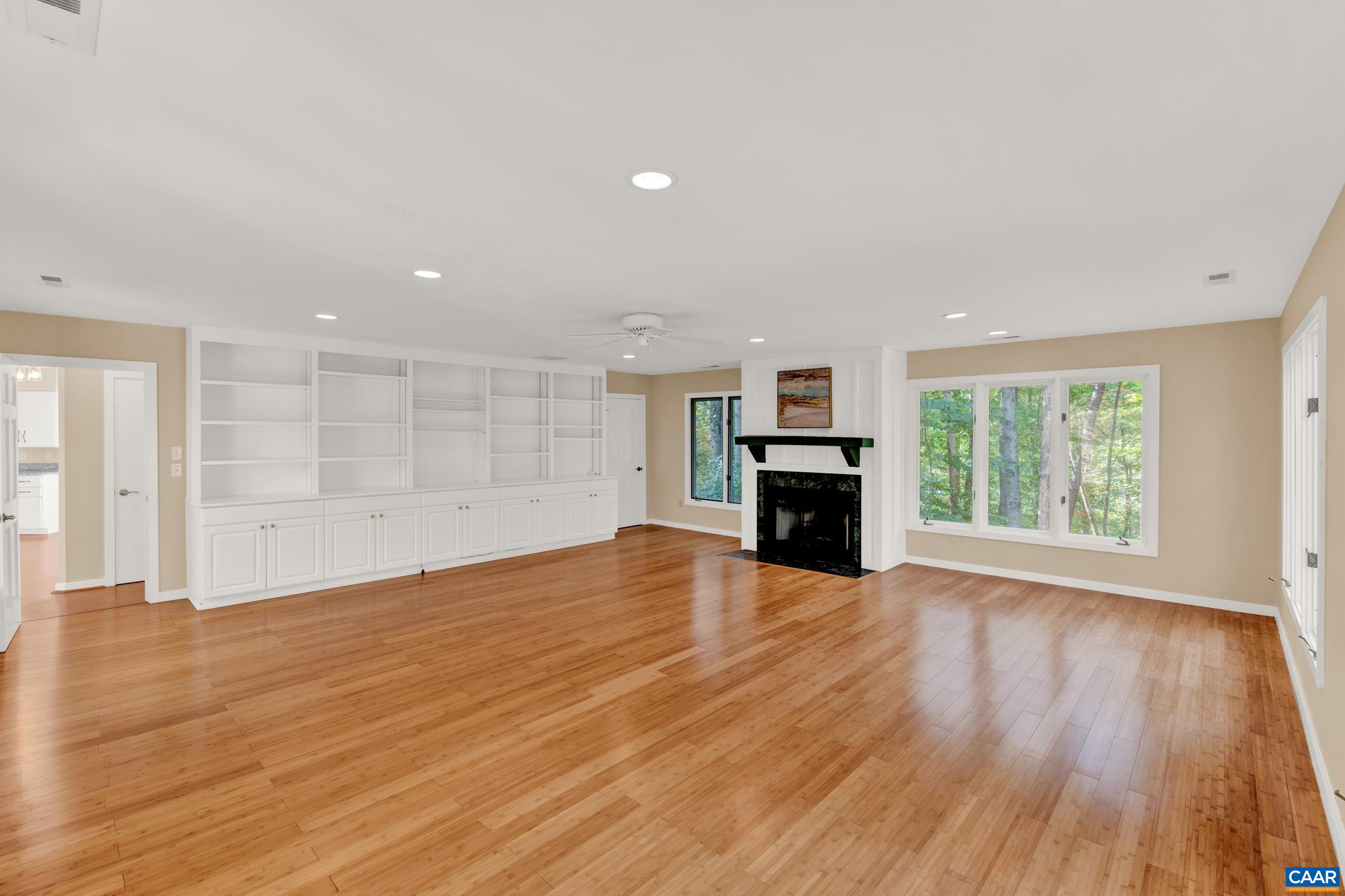 1065 Tilman Road Charlottesville, VA 22901 - Photo 33 of 70 a view of empty room with wooden floor fireplace and windows