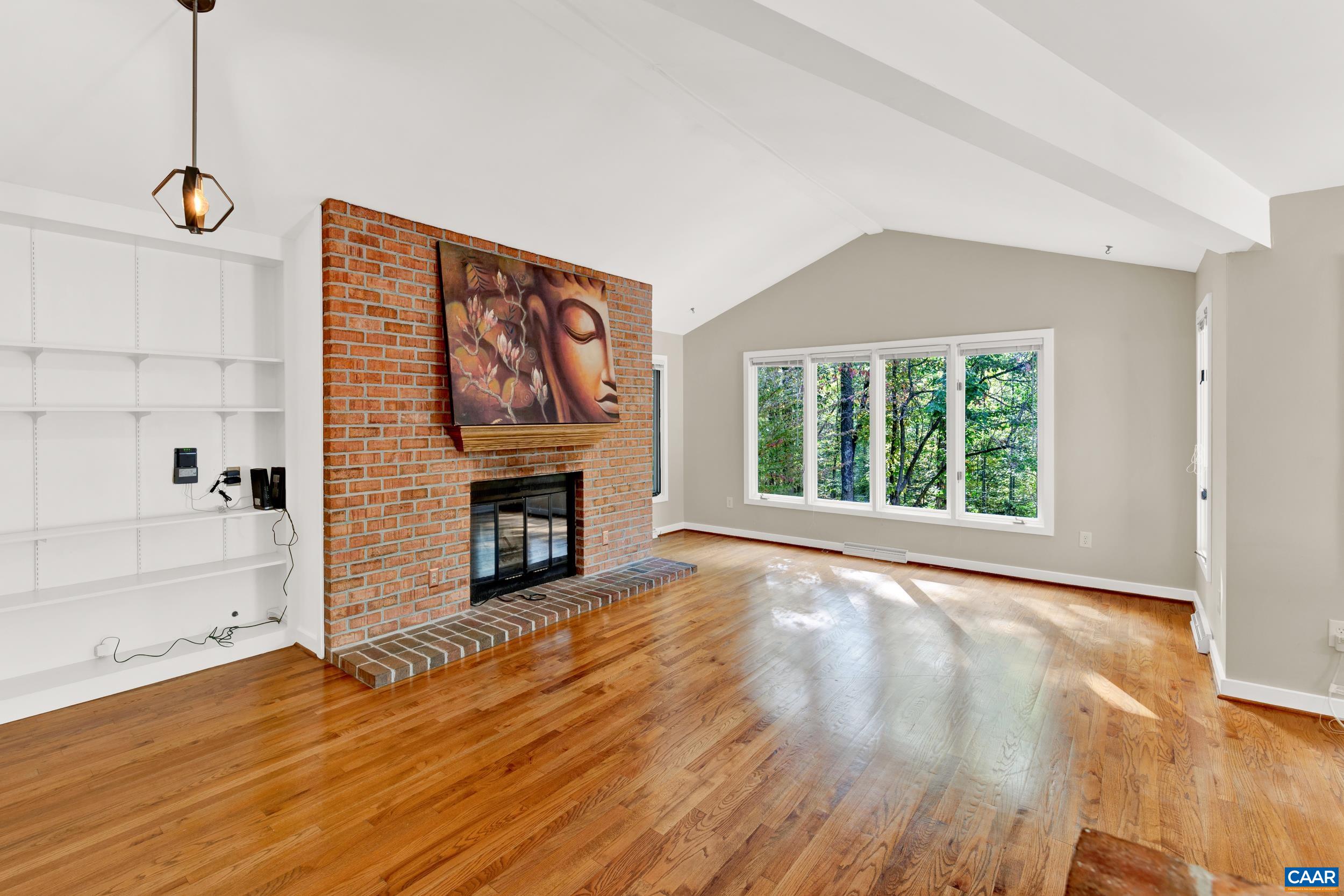 1065 Tilman Road Charlottesville, VA 22901 - Photo 44 of 70 a view of an empty room with wooden floor fireplace and a window