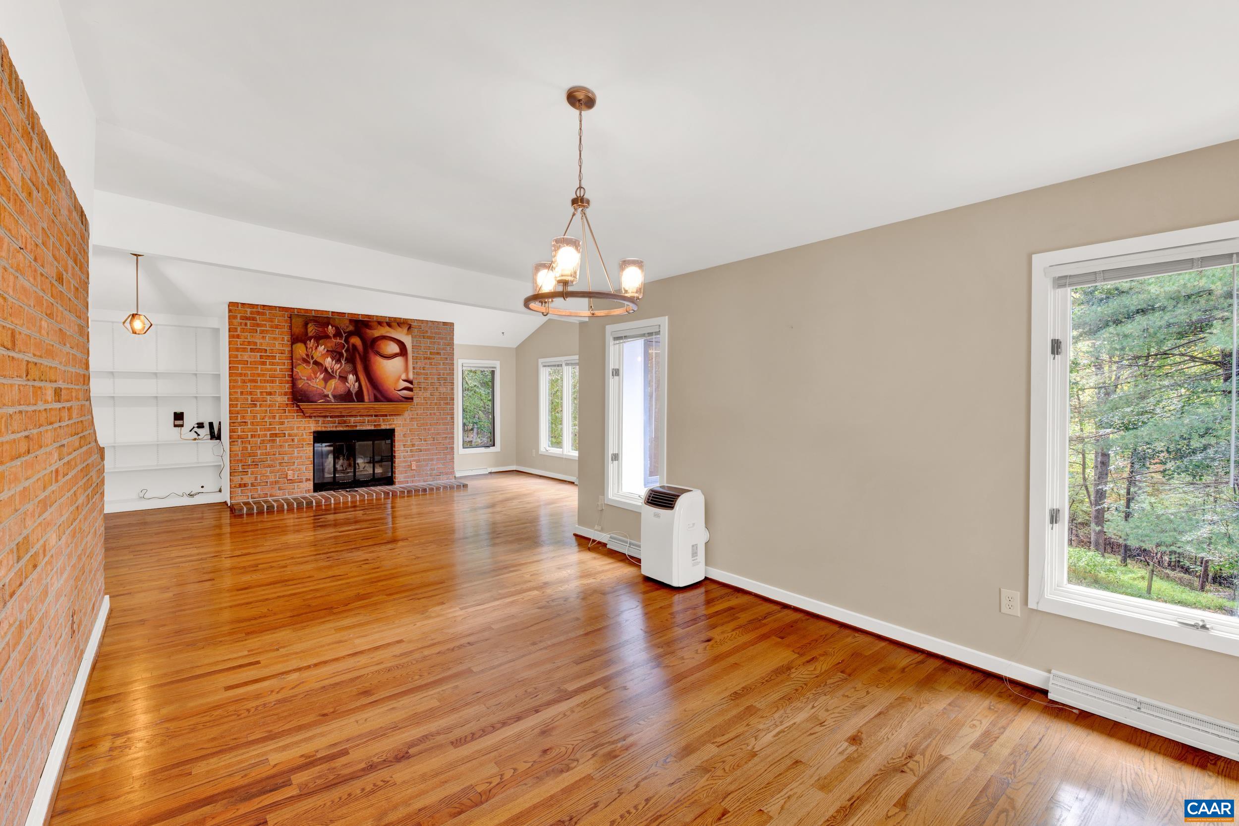 1065 Tilman Road Charlottesville, VA 22901 - Photo 47 of 70 a view of a livingroom with wooden floor a fireplace and windows