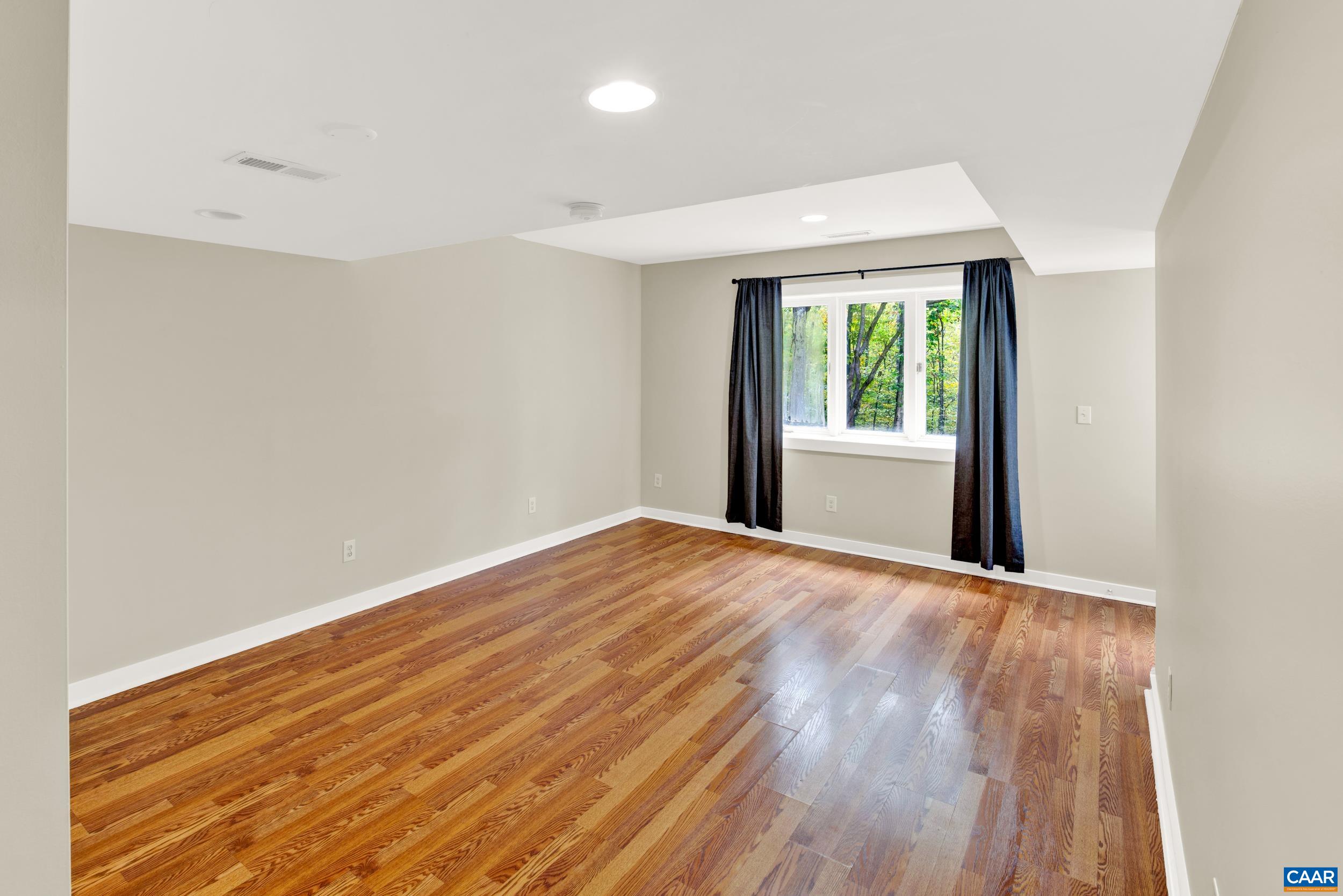 1065 Tilman Road Charlottesville, VA 22901 - Photo 56 of 70 a view of an empty room with wooden floor and a window