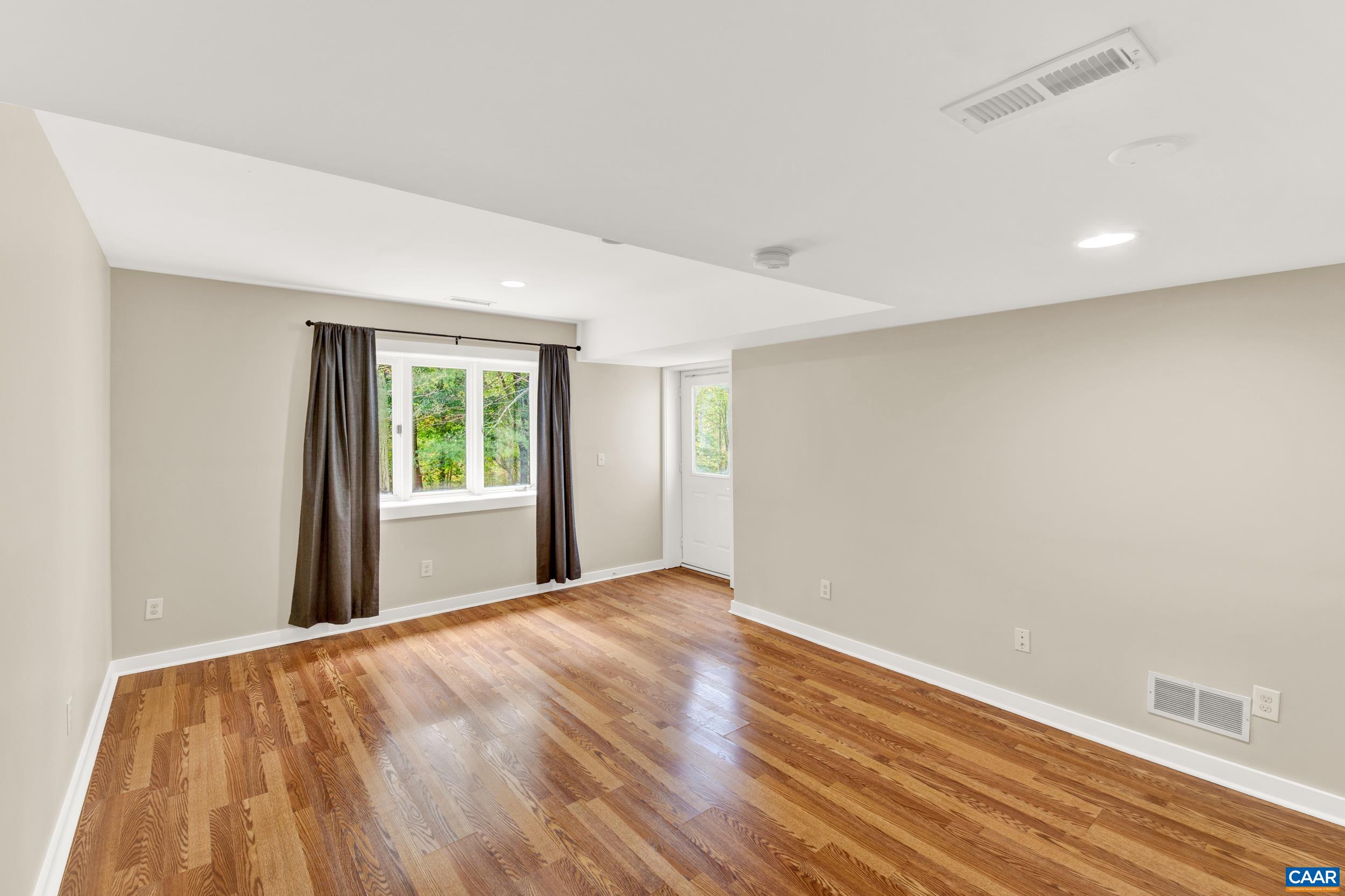 1065 Tilman Road Charlottesville, VA 22901 - Photo 57 of 70 a view of an empty room with wooden floor and a window