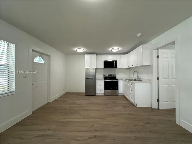 a kitchen with white cabinets and white appliances