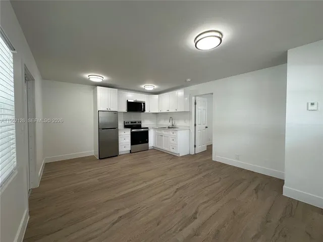 a view of kitchen with stainless steel appliances refrigerator oven and cabinets