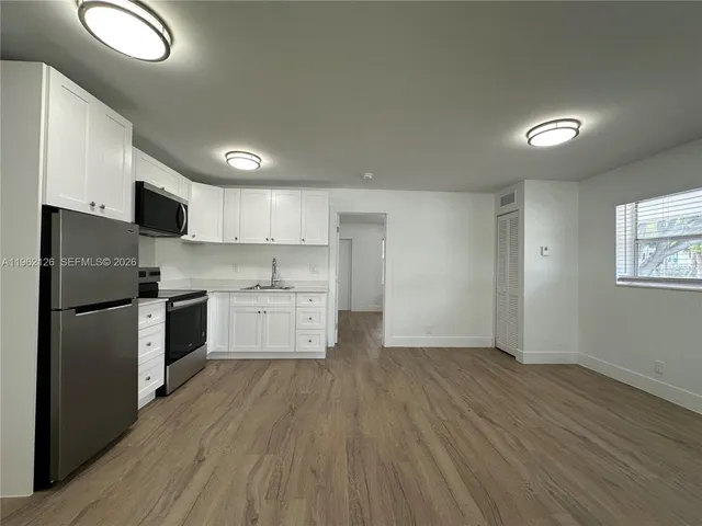 a kitchen with a white cabinets and stainless steel appliances
