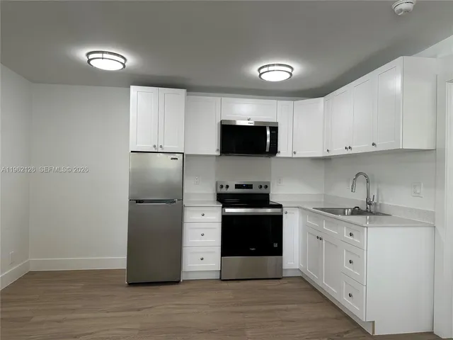 a kitchen with stainless steel appliances granite countertop a refrigerator sink and stove