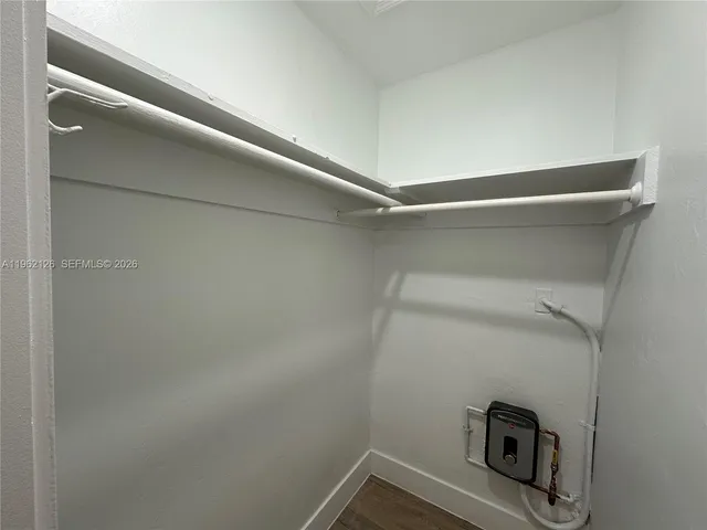 a view of a closet with wooden floor
