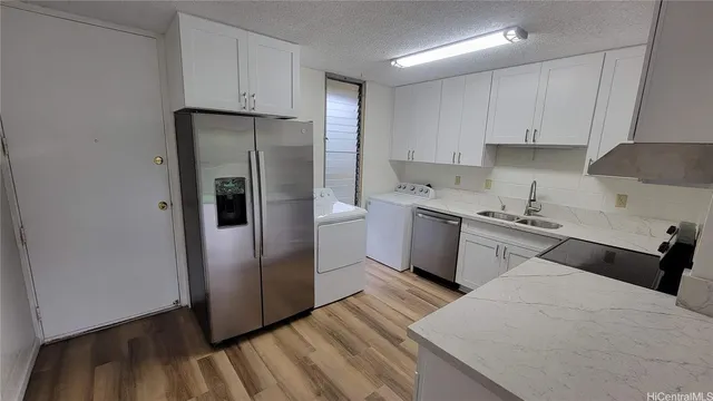 a kitchen with a refrigerator sink and cabinets