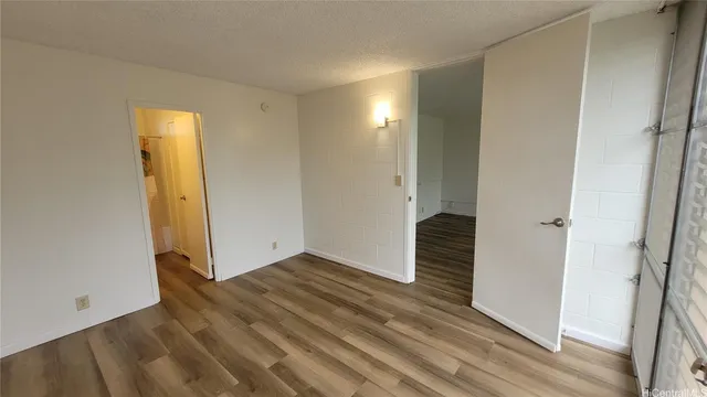 a view of a hallway with wooden floor and closet