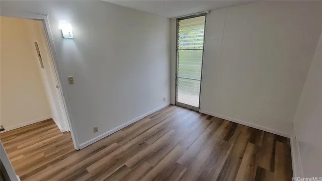 a view of a room with wooden floor and window