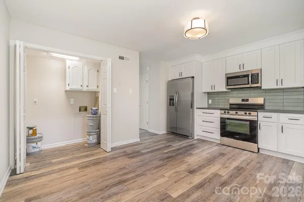 a kitchen with granite countertop a refrigerator and a stove top oven