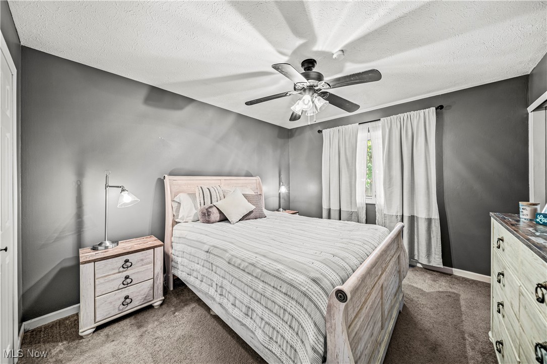 2959 Reeves Road Willoughby, OH 44094 - Photo 11 of 32 Bedroom featuring dark carpet, ceiling fan, and a textured ceiling