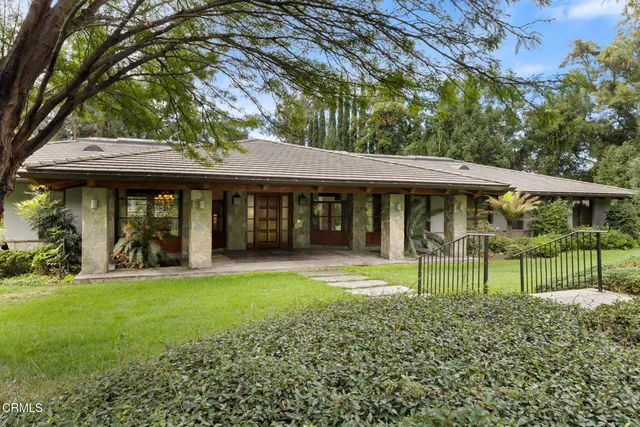 a view of a house with a yard and sitting area