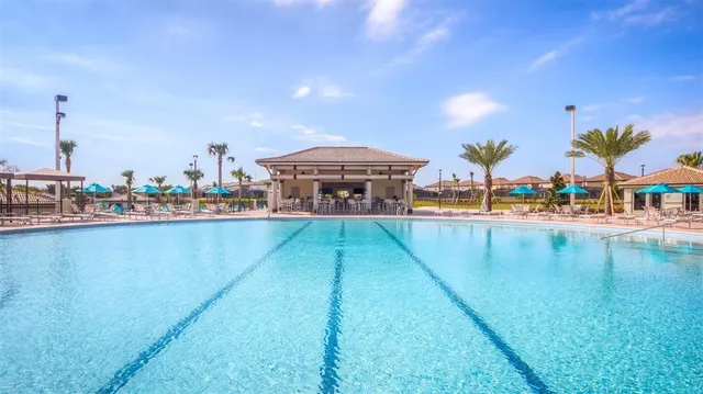 an aerial view of a swimming pool with outdoor seating and yard