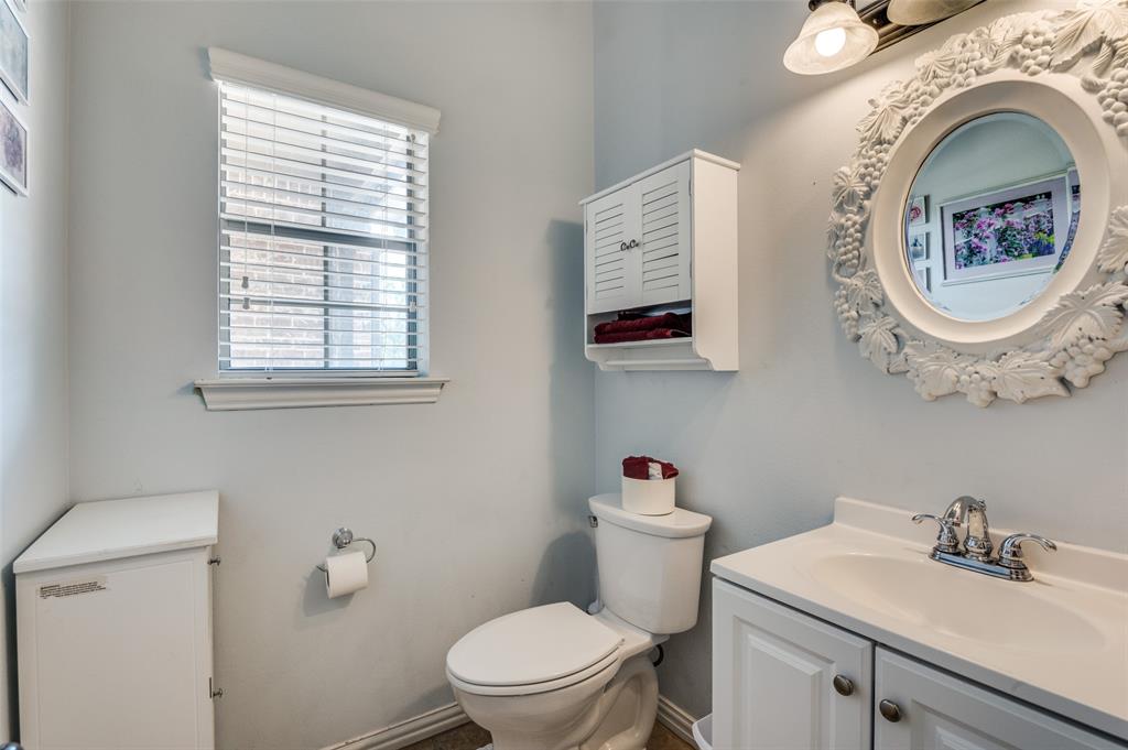 336 Maggie Street Canton, TX 75103 - Photo 19 of 30 a bathroom with a toilet a sink and a mirror