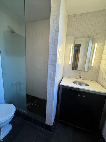 a bathroom with a sink and mirror with toilet