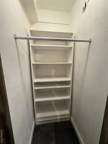 a view of walk in closet with empty racks