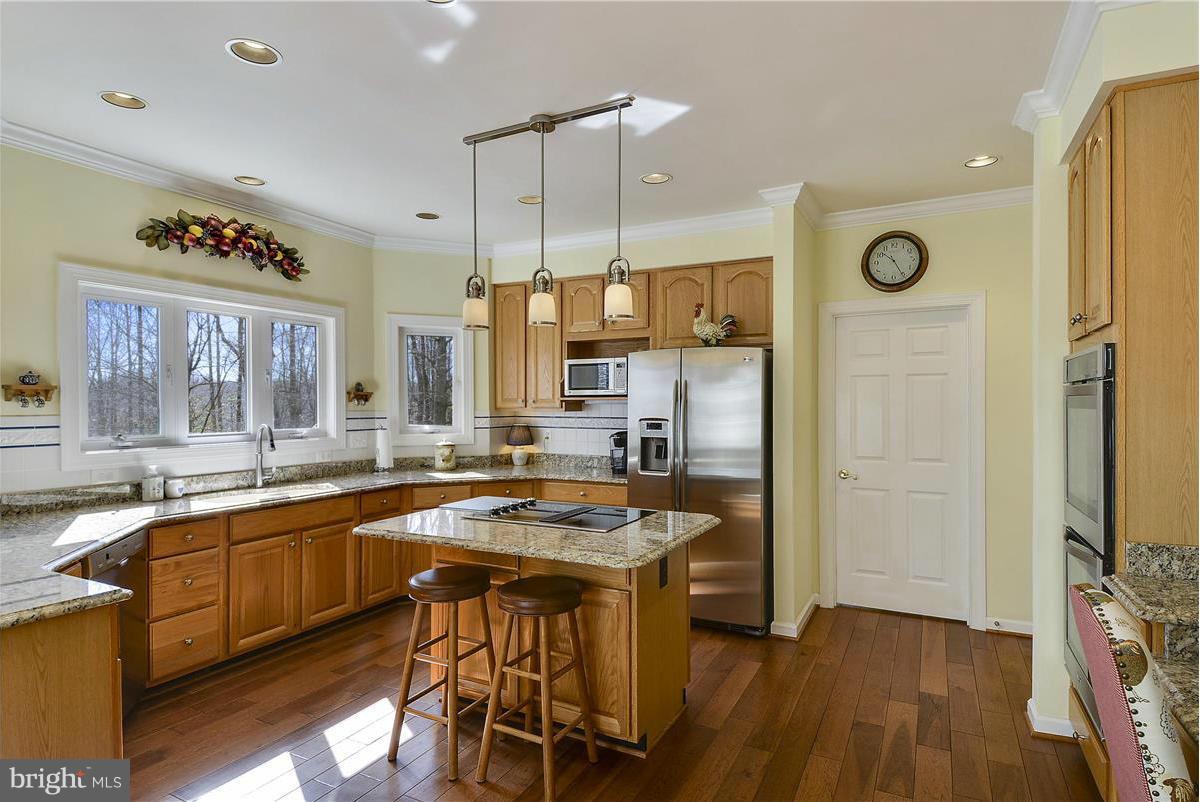 10839 Moore Drive Manassas, VA 20111 - Photo 5 of 30 a kitchen with wooden cabinets and center island