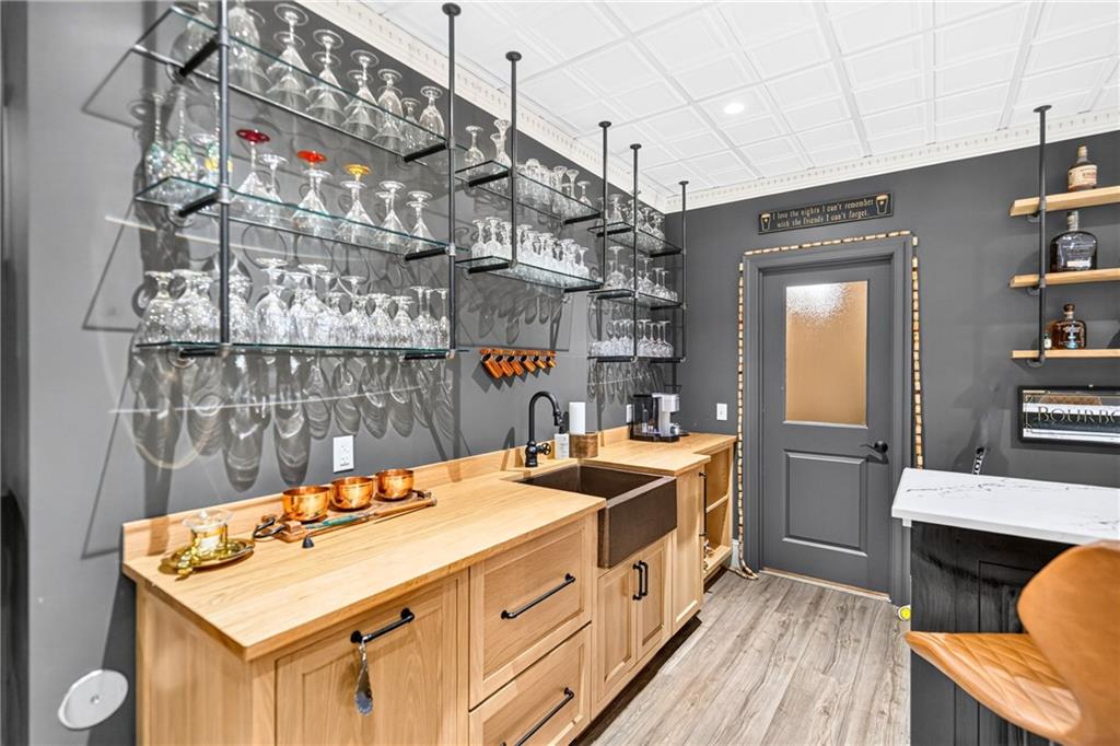 486 Settler Road Ligonier, PA 15658 - Photo 37 of 49 In addition to this gorgeous shelving for your barware, we have custom oak integrated ice maker, double dishwasher, and copper sink. And you ask what's behind the door? click to the next pic.