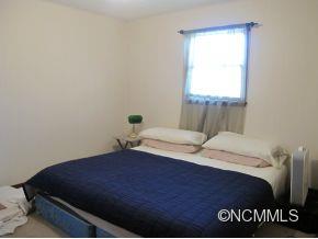 158 Howell Cove Road Canton, NC 28716 - Photo 12 of 14 a bedroom with a bed and window
