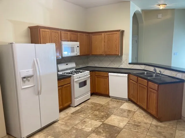 a kitchen with stainless steel appliances granite countertop a stove a sink and a refrigerator