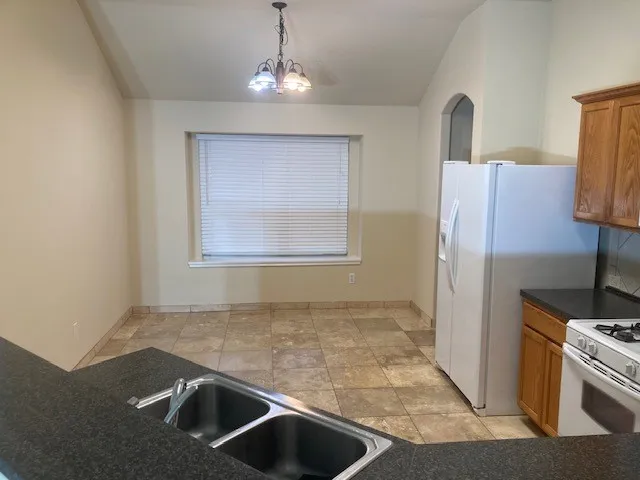 a view of a kitchen with a sink and a refrigerator