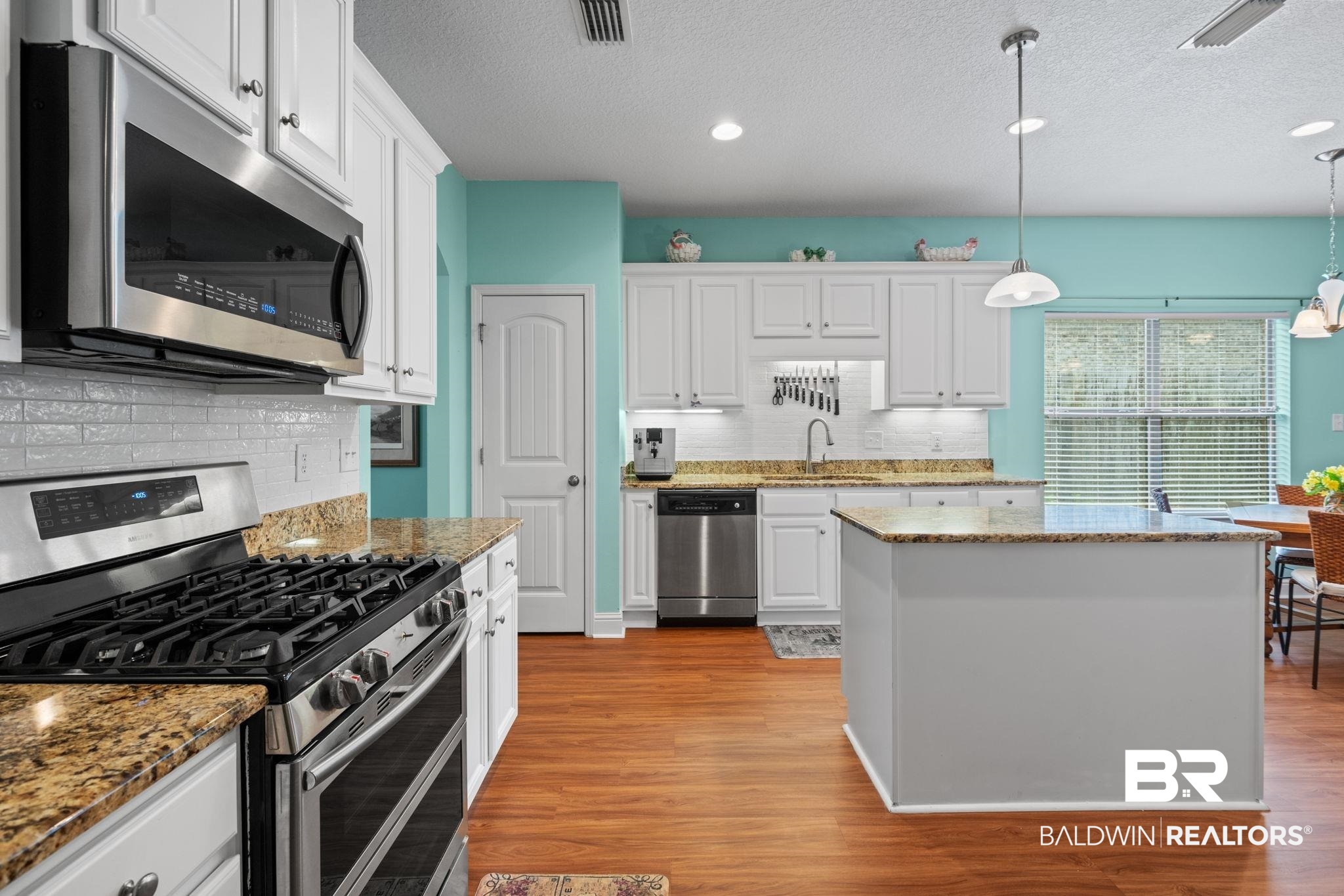 2554 Masters Court Mobile, AL 36618 - Photo 11 of 35 Kitchen featuring appliances with stainless steel finishes, tasteful backsplash, a textured ceiling, white cabinets, and light wood-type flooring