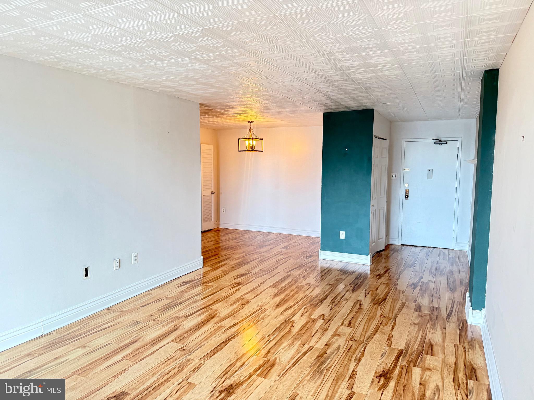a view of an empty room with wooden floor
