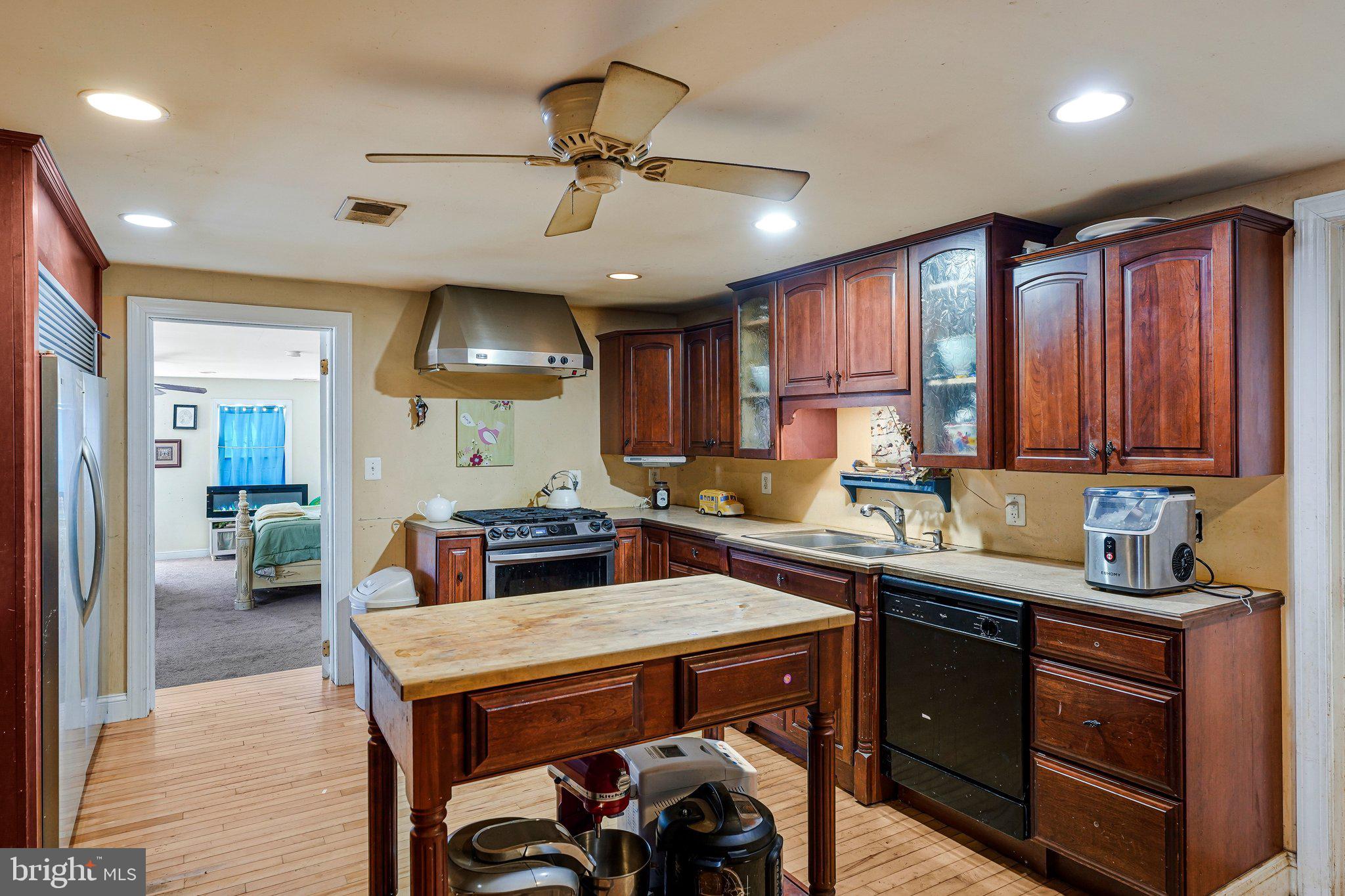 14757 Beamertown Road Purcellville, VA 20132 - Photo 7 of 28 a kitchen with a stove a refrigerator a sink dishwasher with a dining table and chairs with wooden floor