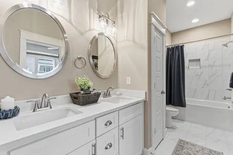 a bathroom with a double vanity sink mirror and toilet