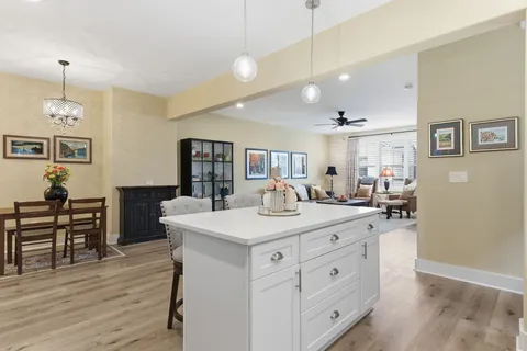 a view of a kitchen counter space a sink wooden floor and living room view