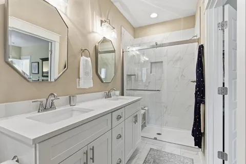 a bathroom with a sink vanity granite shower and a mirror