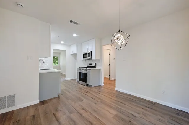 a kitchen with a refrigerator and white cabinets