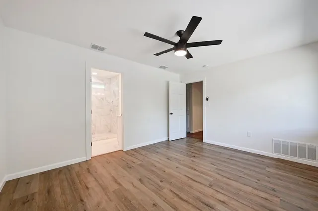 a view of a big room with wooden floor and windows