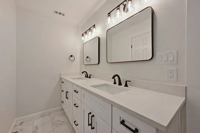 a bathroom with a sink vanity and mirror