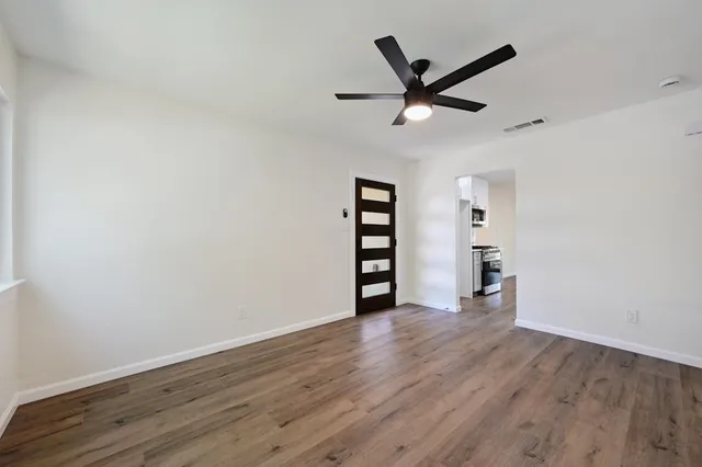 a view of a livingroom with a hardwood floor and a ceiling fan