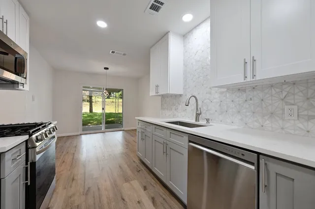 a kitchen with a sink stove and cabinets