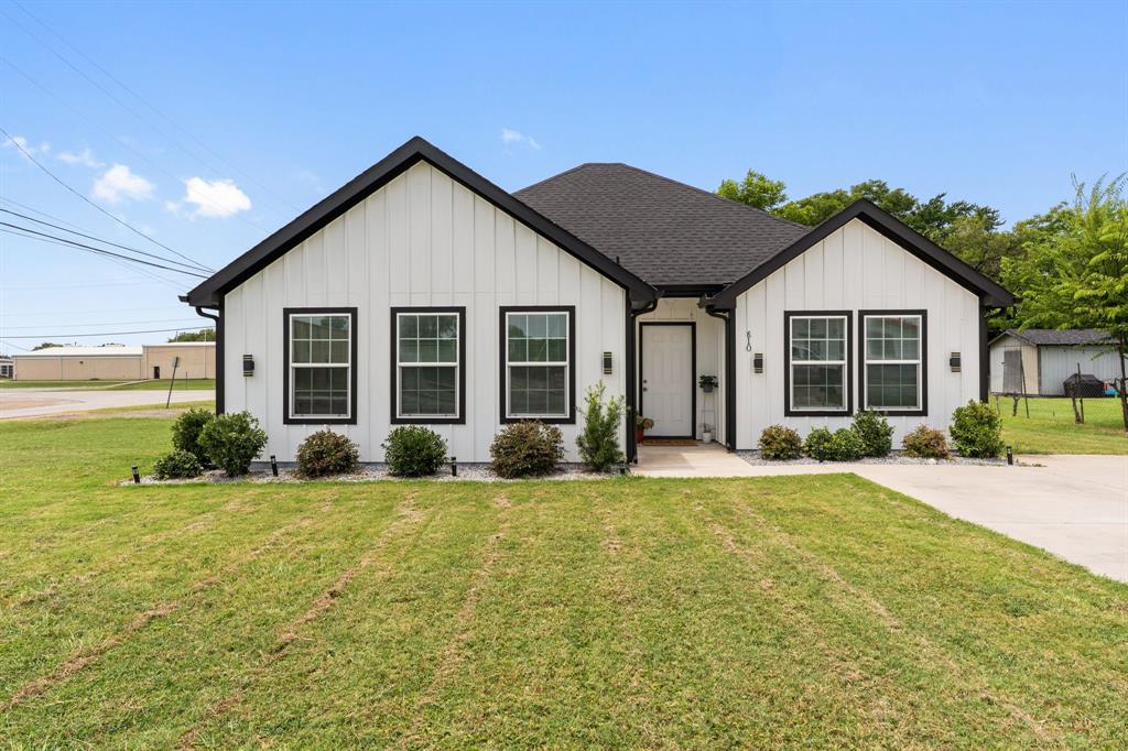 a view of a house with a yard and large tree