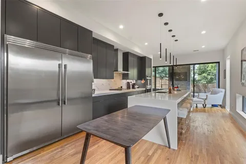a kitchen with a refrigerator a sink and wooden floor