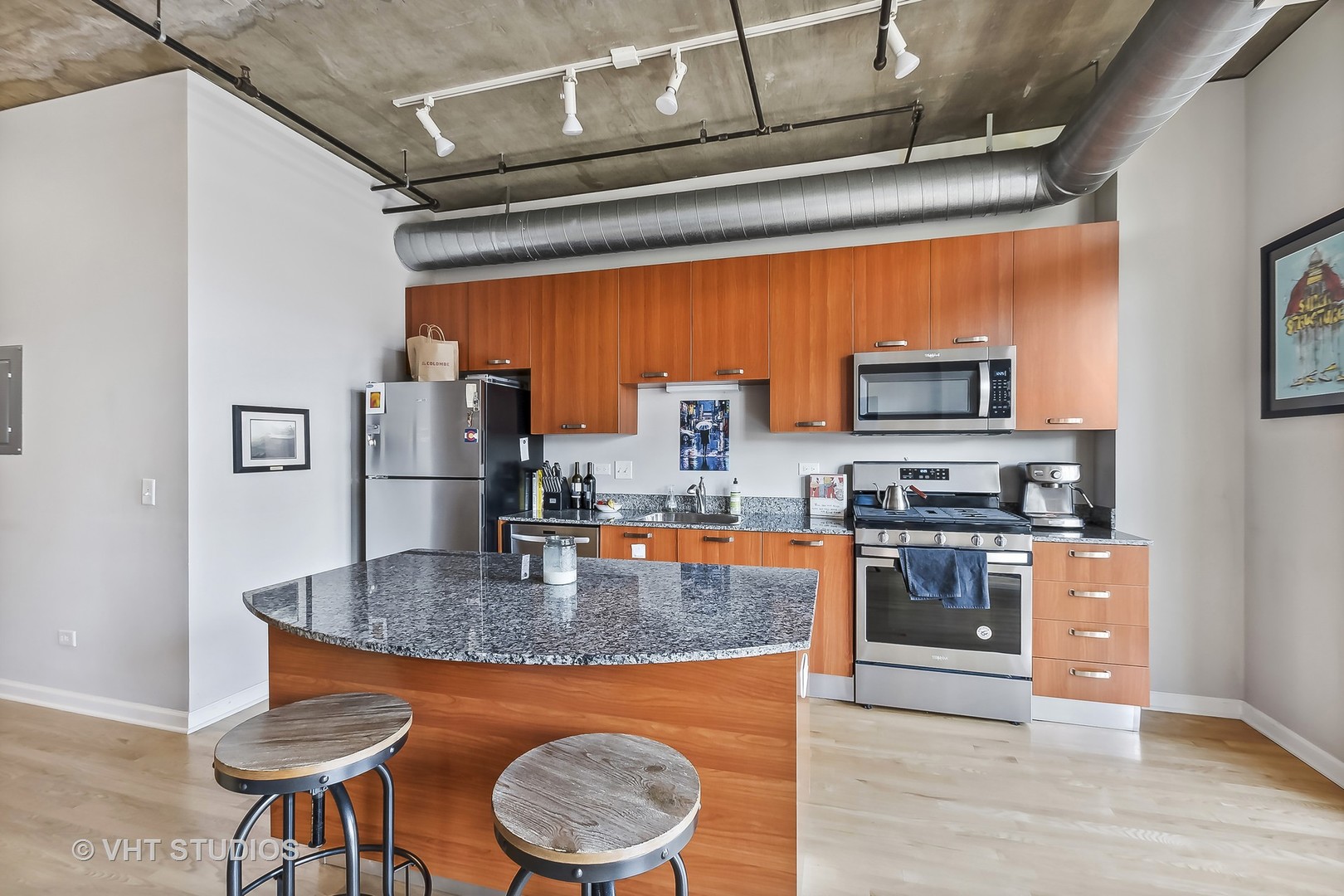 111 South Morgan Street, Unit 620 Chicago, IL 60607 - Photo 5 of 13 a kitchen with stainless steel appliances granite countertop a stove a refrigerator a microwave oven with a dining table and chairs