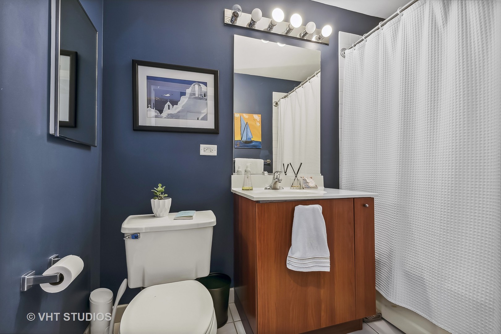 111 South Morgan Street, Unit 620 Chicago, IL 60607 - Photo 9 of 13 a bathroom with a toilet a sink and mirror