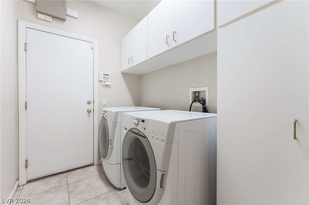 10481 Riverside Park Avenue Las Vegas, NV 89135 - Photo 29 of 51 Laundry room with cabinet space, washing machine and dryer, and light tile patterned flooring