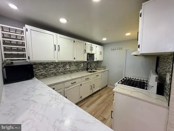 a kitchen with a sink a stove and cabinets