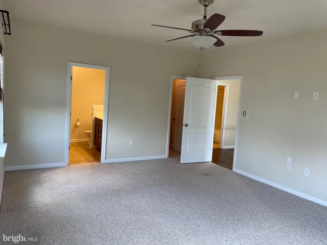 a view of an empty room with a ceiling fan