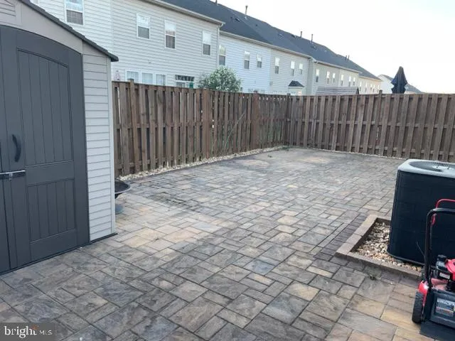a view of backyard with tub and wooden fence