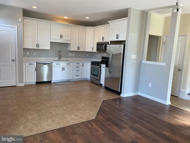 a kitchen with stainless steel appliances a refrigerator and a stove top oven