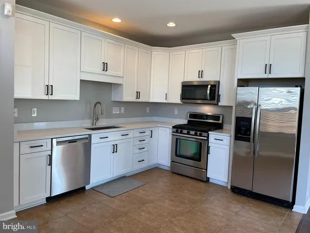 a kitchen with stainless steel appliances a refrigerator sink and cabinets