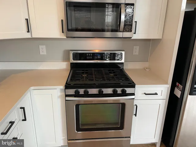 a kitchen with cabinets stainless steel appliances and a sink