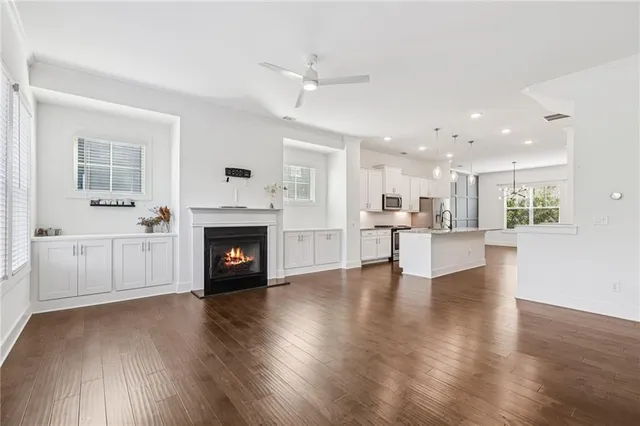 a view of a kitchen with a fireplace a ceiling fan and wooden floor