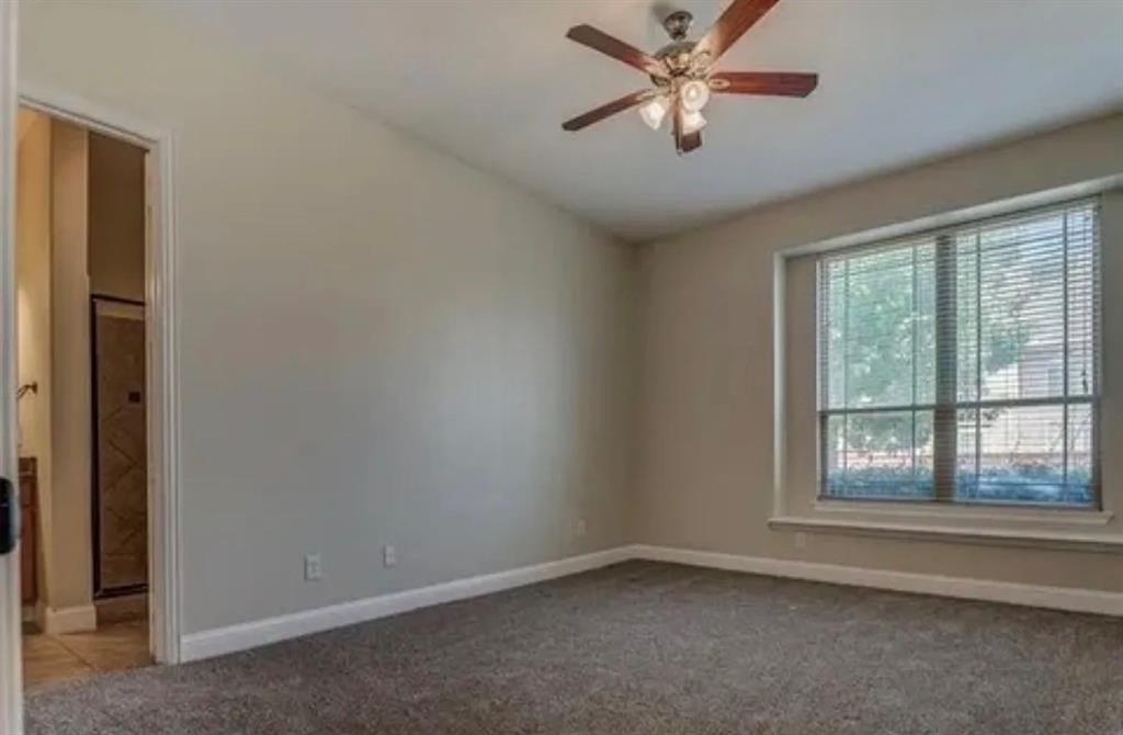 228 Wallington Way Lewisville, TX 75067 - Photo 2 of 22 an empty room with windows and fan